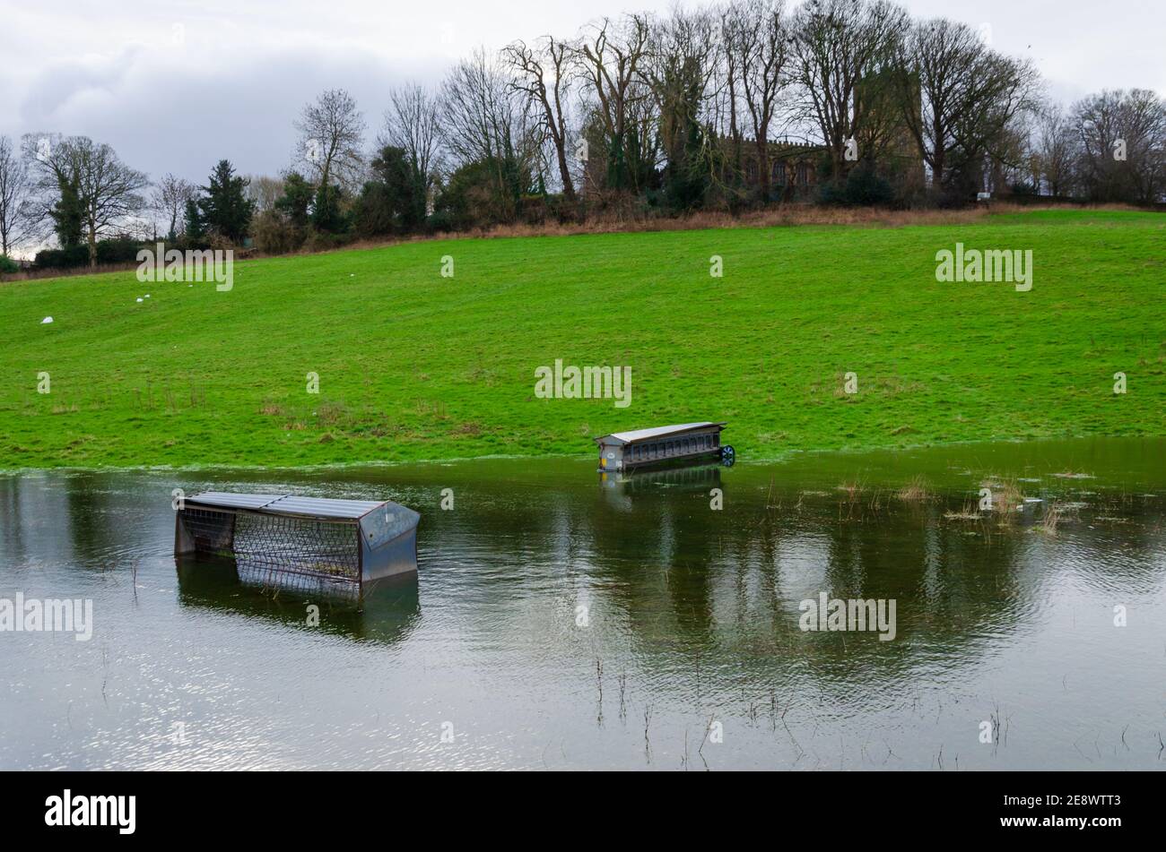 Mold, Flintshire; UK: Jan 28, 2021: Sheep feeders have been partially submerged in a field which has been badly flooded during the recent heavy rainfa Stock Photo