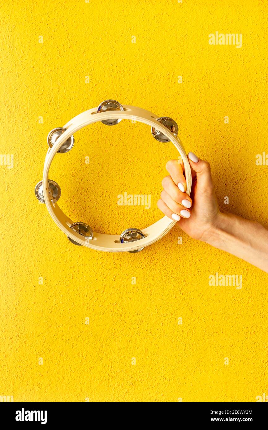 Wooden tambourine in hand. Percussion musical instrument, top view