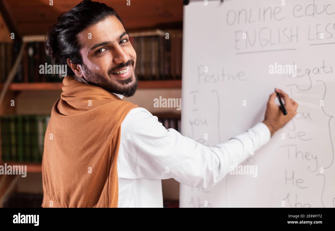Arab Teacher Writing On Blackboard Having Online Lecture Indoor Stock Photo