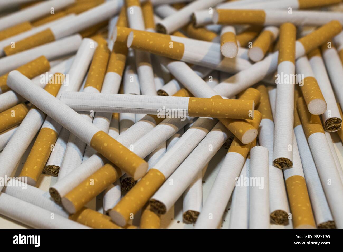 shots cigarettes Vertical shot of a smoked cigarette in the background of many other in a round shape Stock Photo Many genes linked to alcohol