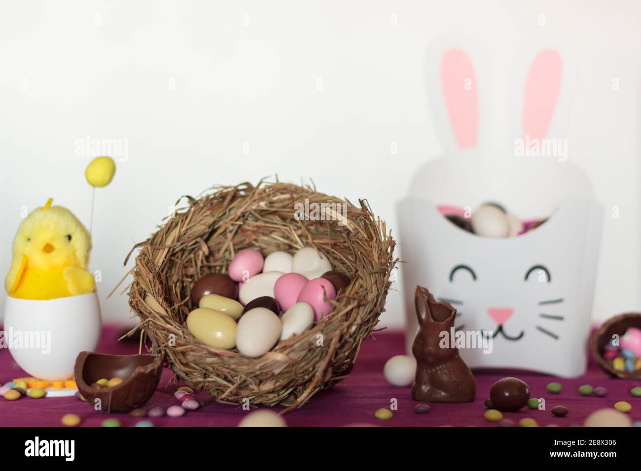 Bird nest with easter almond eggs, chocolate bunny missing a bite