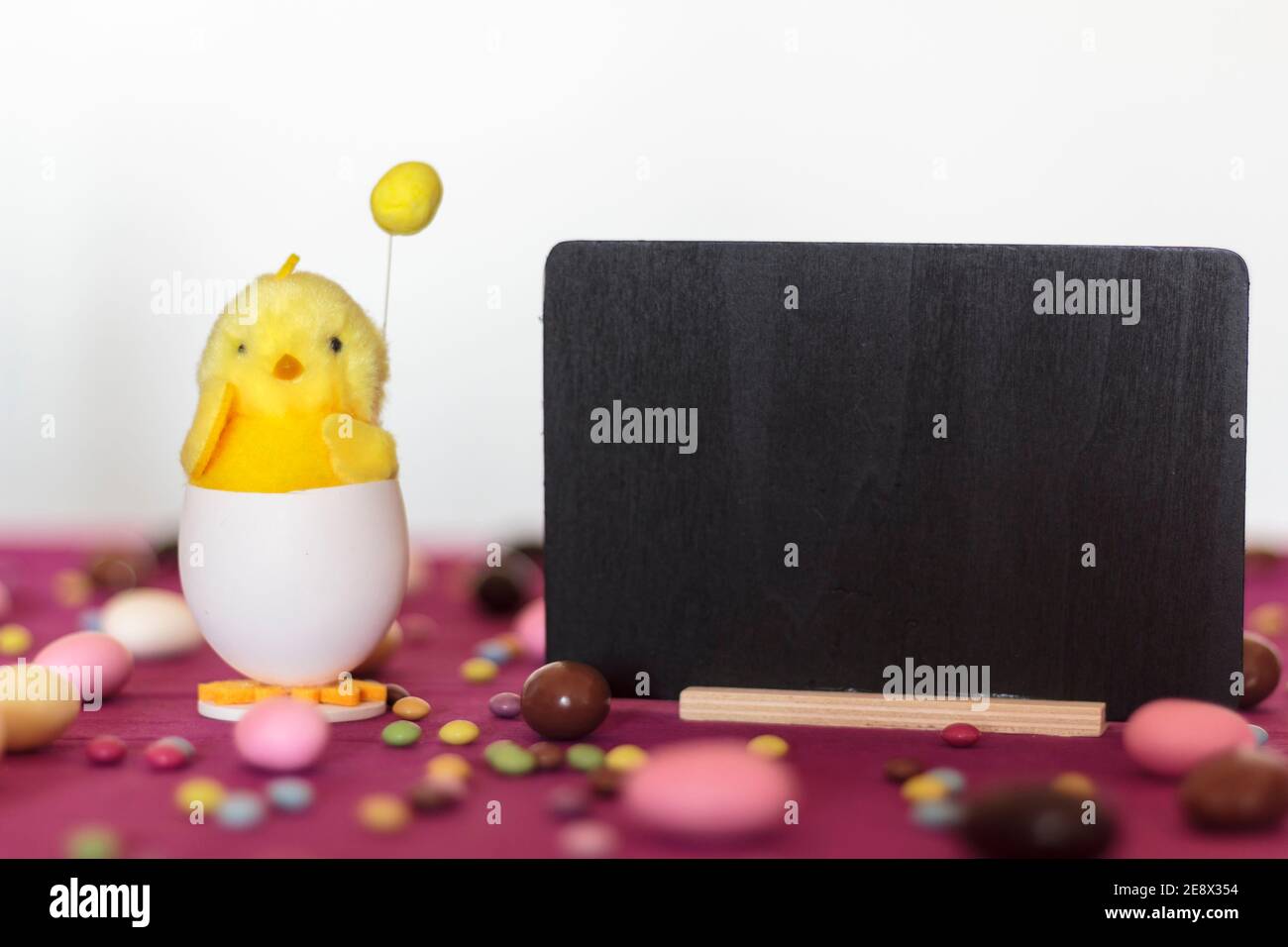 Decorative chick, easter sweets and blackboard with copy space. Easter holiday concept Stock Photo