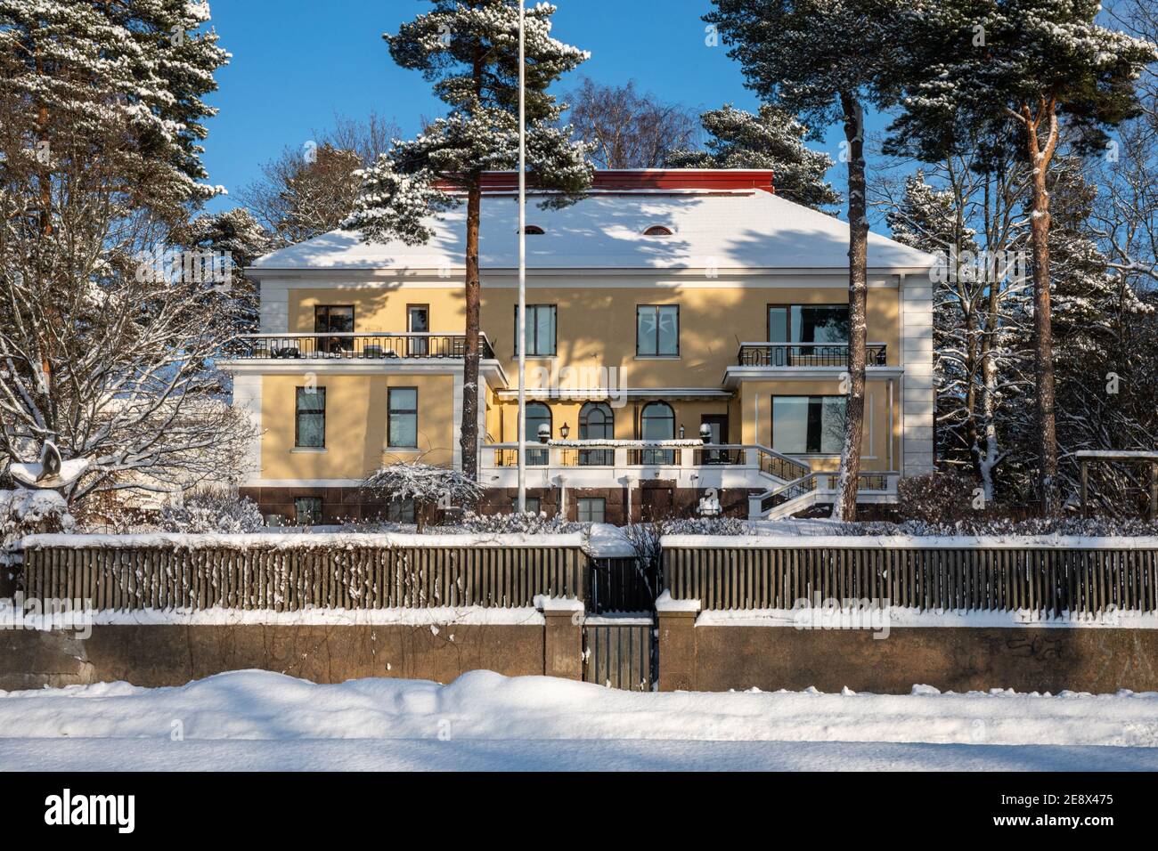 Residential building by Munkkiniemenranta on a sunny winter day with snow and clear blue sky in Munkkiniemi district of Helsinki, Finland Stock Photo