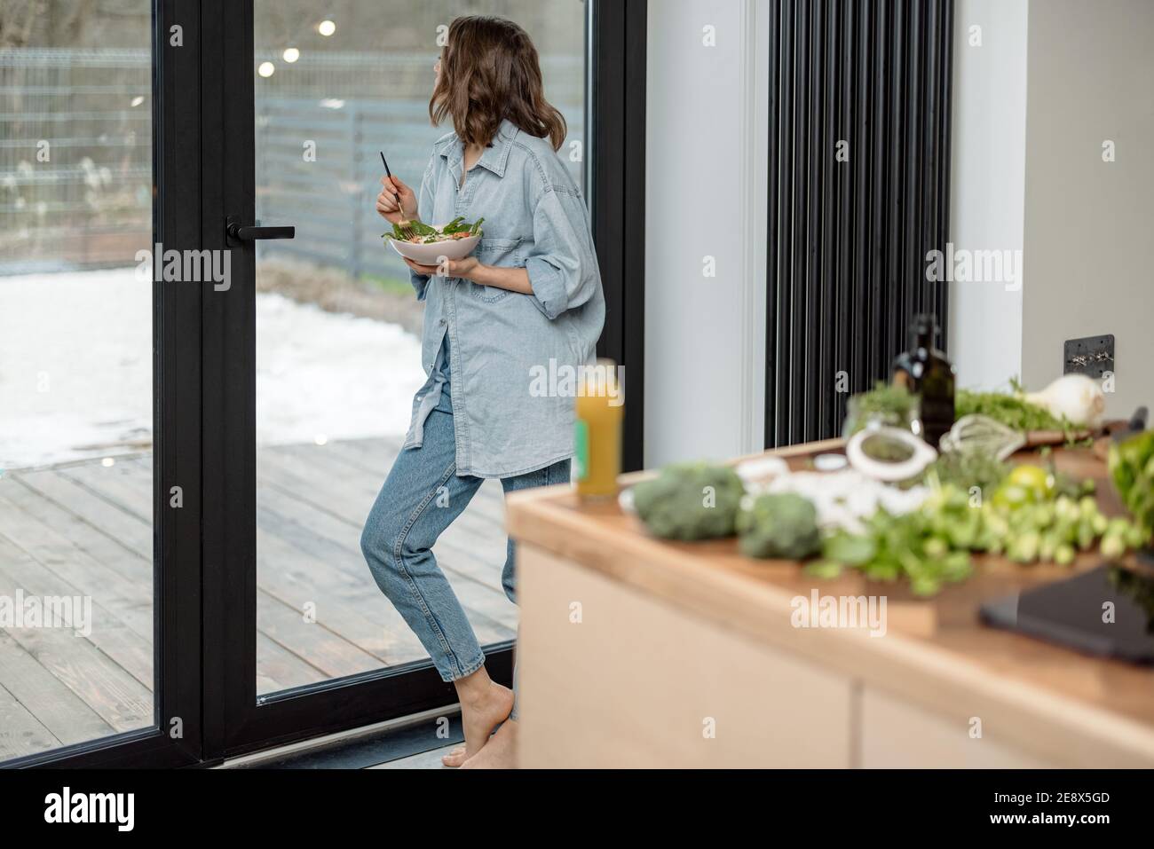 Woman eating healthy green salad at home Stock Photo