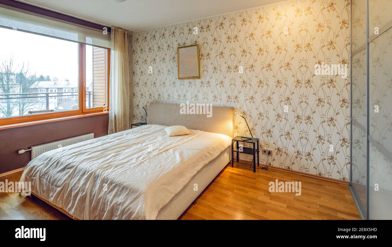 Modern interior of bedroom in luxury apartment. Cozy bed. Huge window ...