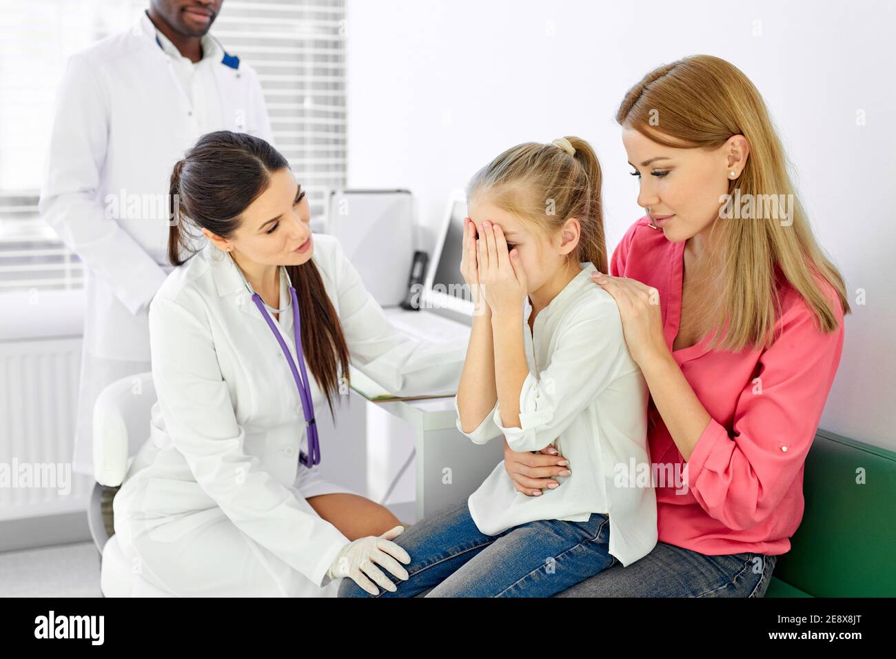 female doctor general practitioner talks and amuses child before