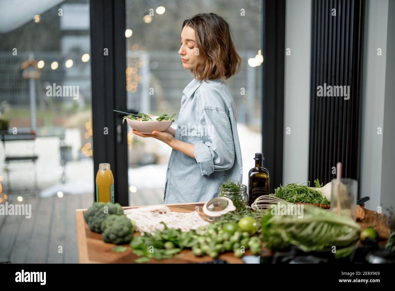 Woman eating healthy green salad at home Stock Photo