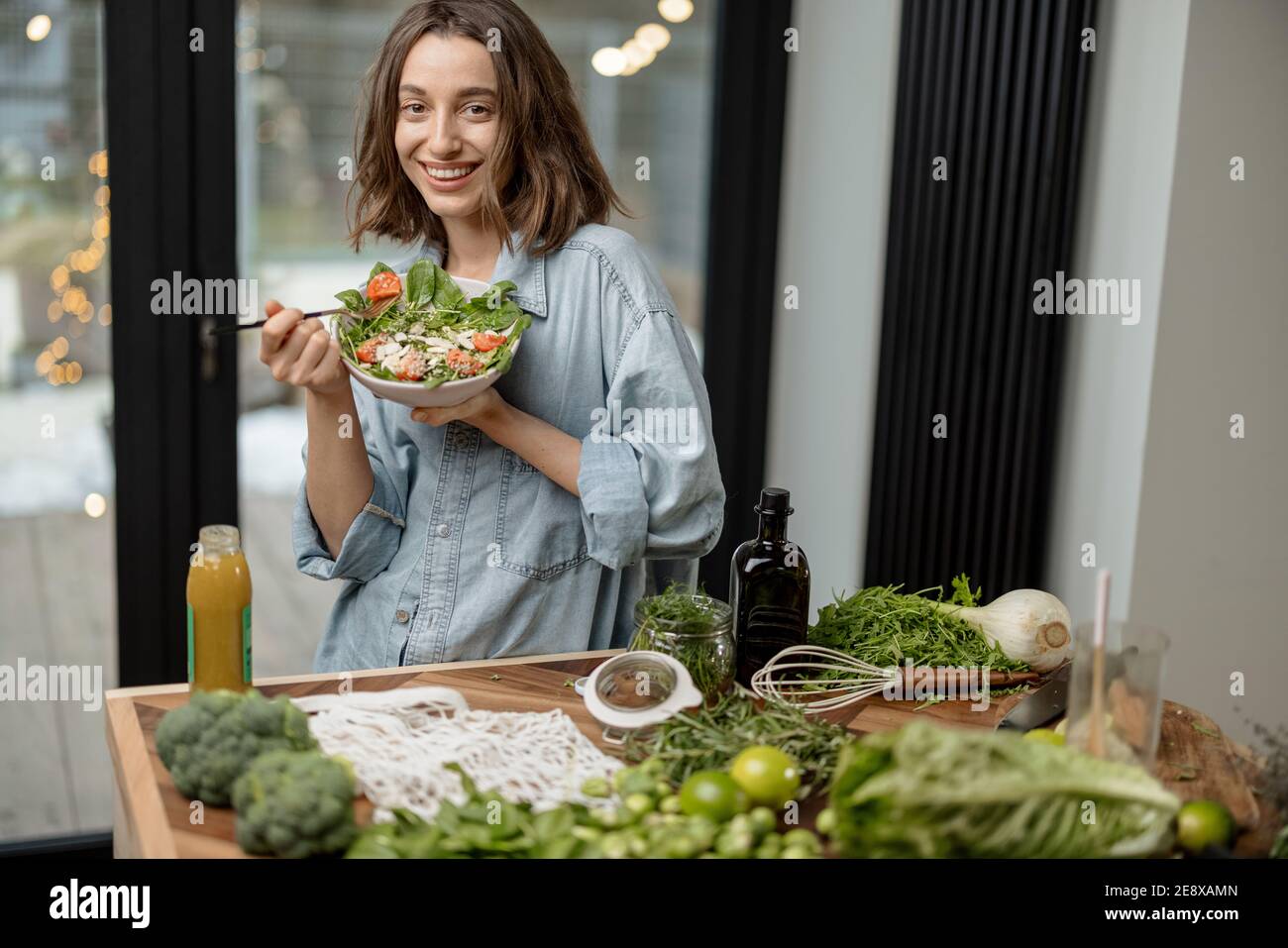 Woman eating healthy green salad at home Stock Photo
