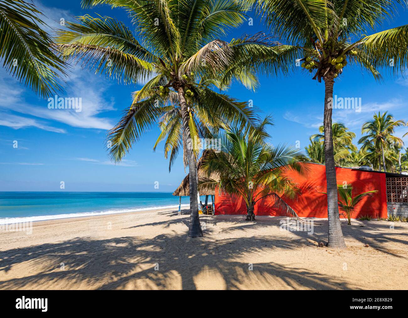 Red house on the beach looking out at the azure water of Lo De Marcos on the Pacific Coast of Nayarit, Mexico. Stock Photo