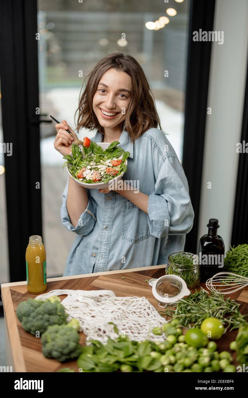 Woman eating healthy green salad at home Stock Photo