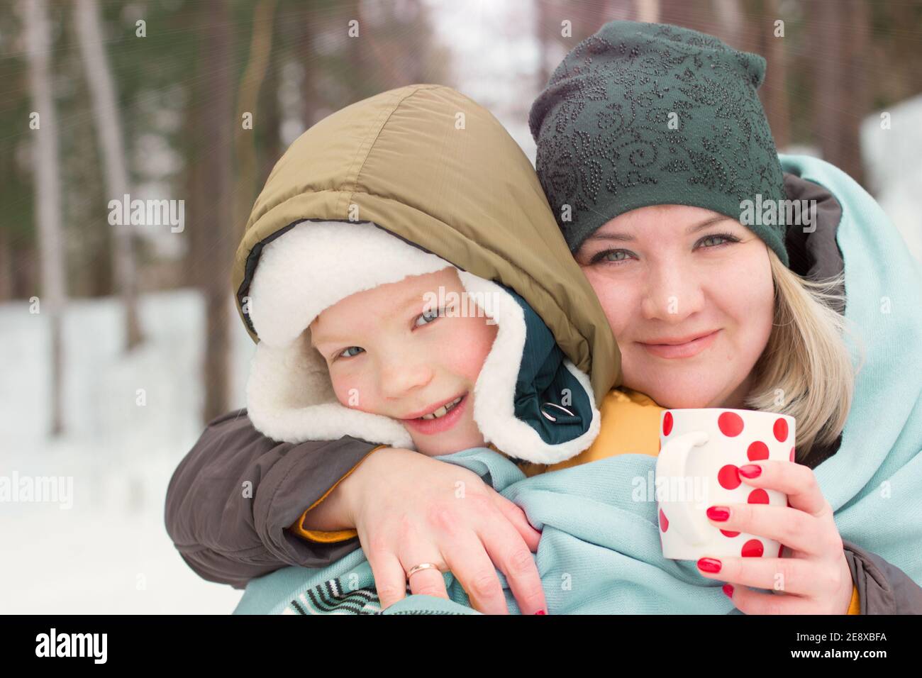 mother and son cuddling and holding cup of tea. togetherness and ...