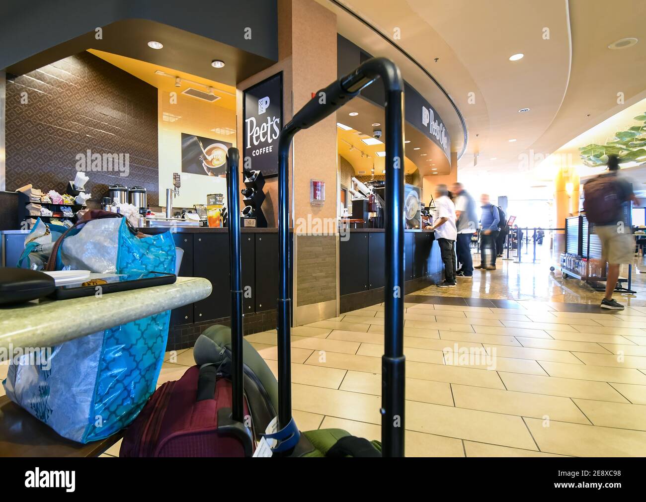 Travelers wait in line at a Peet's Coffee stand shop inside the Seattle Terminal Airport, in Seattle, Washington, USA. Stock Photo