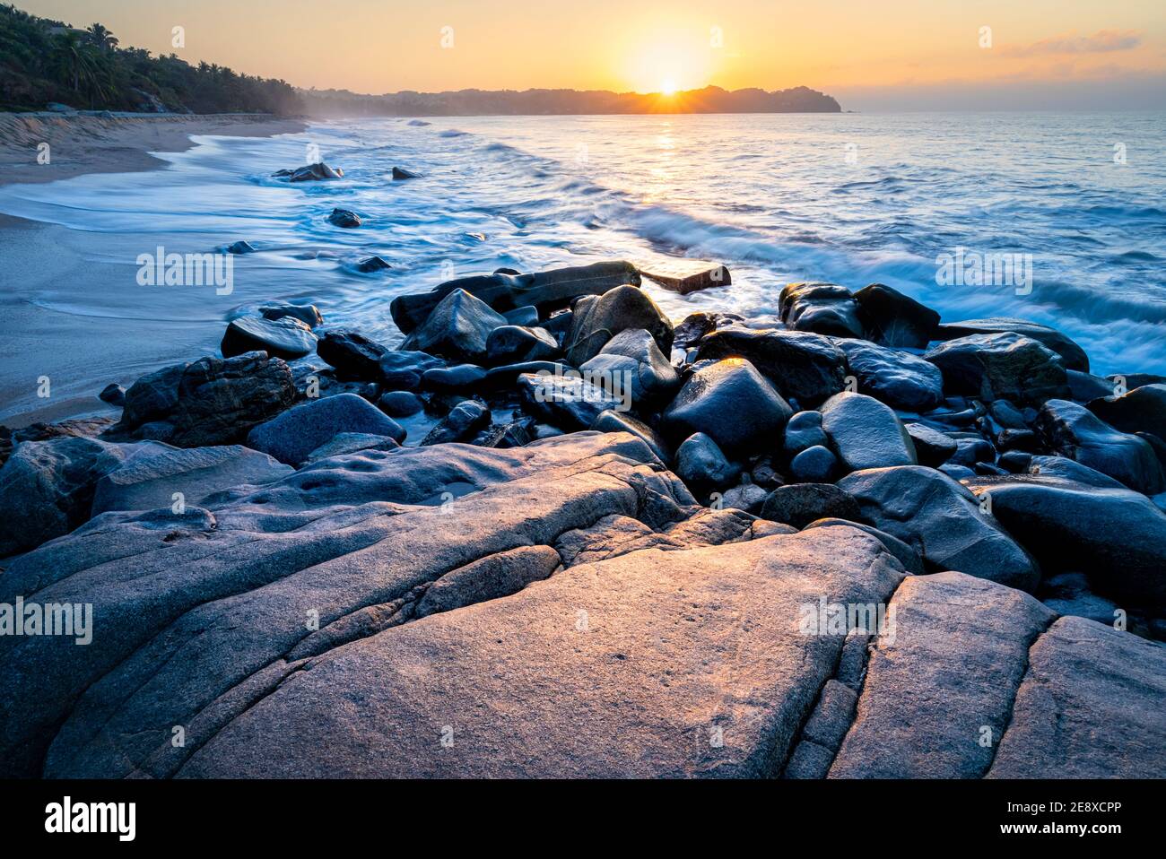 Rocks reflect the sunset on the beach near Sayulita, Nayarit, Mexico. Stock Photo