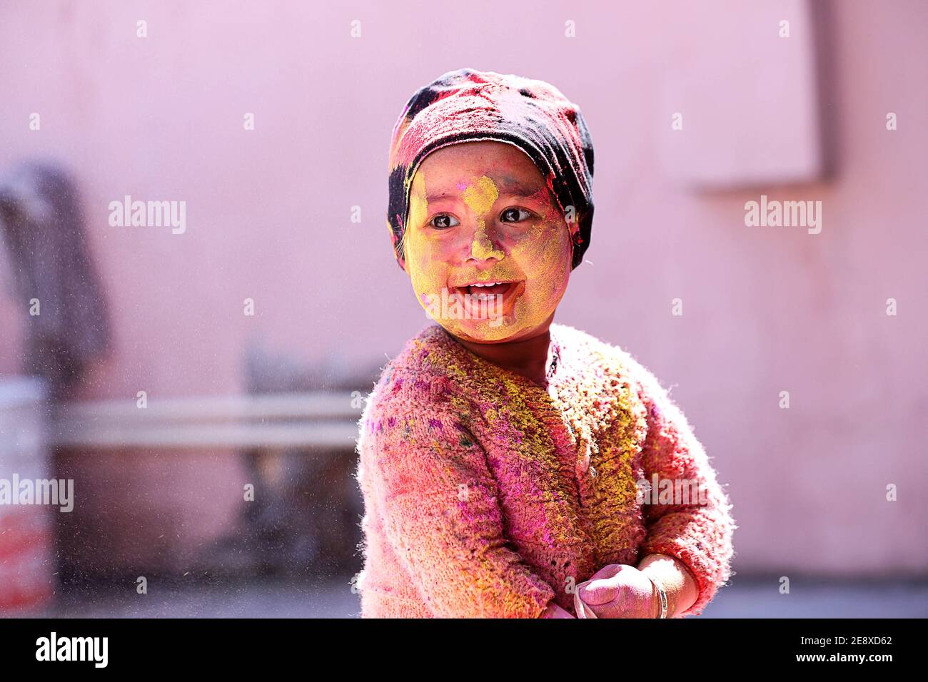 Indian Kid smiling portrait playing with colors on the occasion of holi Color of festival Stock Photo