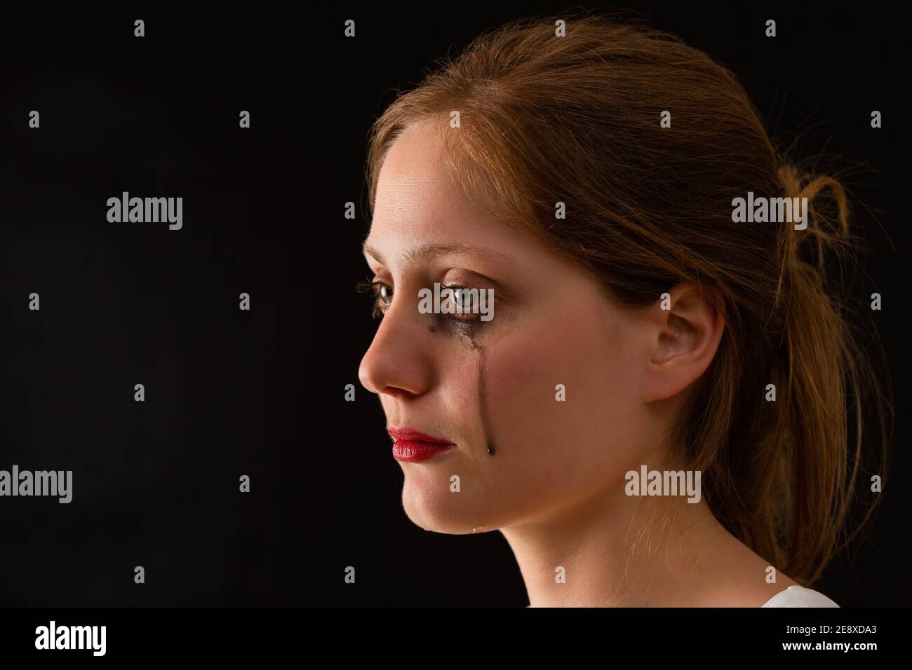 Crying female with tears falling from eyes from close up Stock Photo