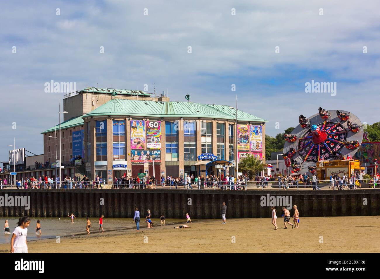 Weymouth Pavilion, beach and fairground ride on a warm sunny day for