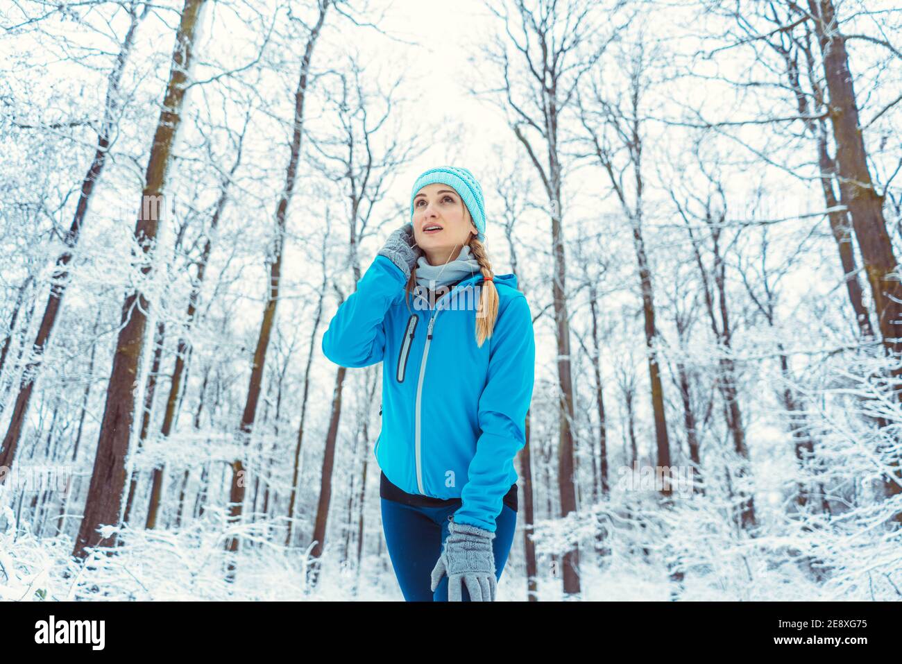 Woman wearing functional clothing in snow warming up for sports Stock Photo