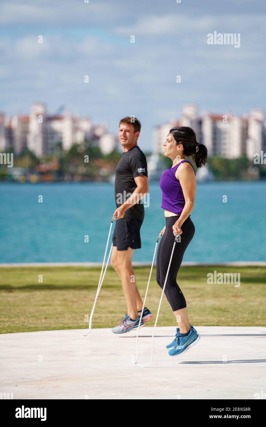 Healthy fit couple jump rope in the park candid street photography Stock Photo
