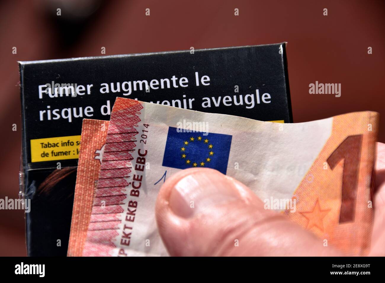 France. 31st Jan, 2021. In this photo illustration a close-up of a 10 euro  bill seen displayed on a cigarette packet.Some brands of cigarettes will  see their price increase by around ten