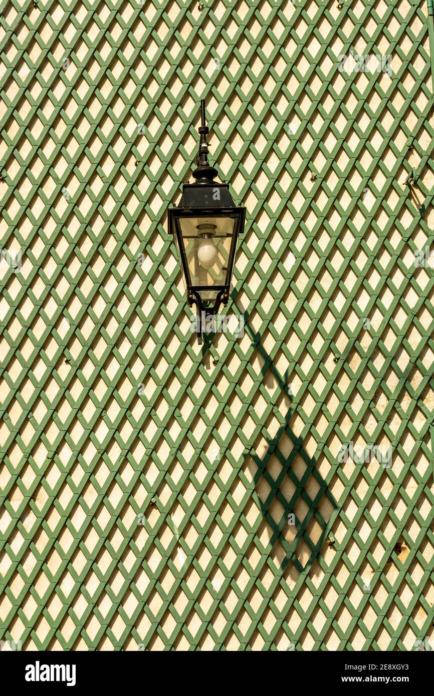 Shadow of a lantern on a green wooden lattice wall, Auvergne-Rhone-Alpes, France Stock Photo