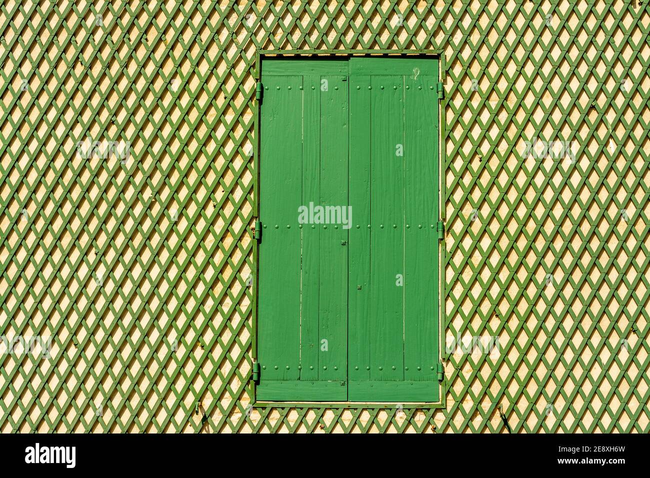 Green window on a wooden lattice wall, Auvergne-Rhone-Alpes, France Stock Photo