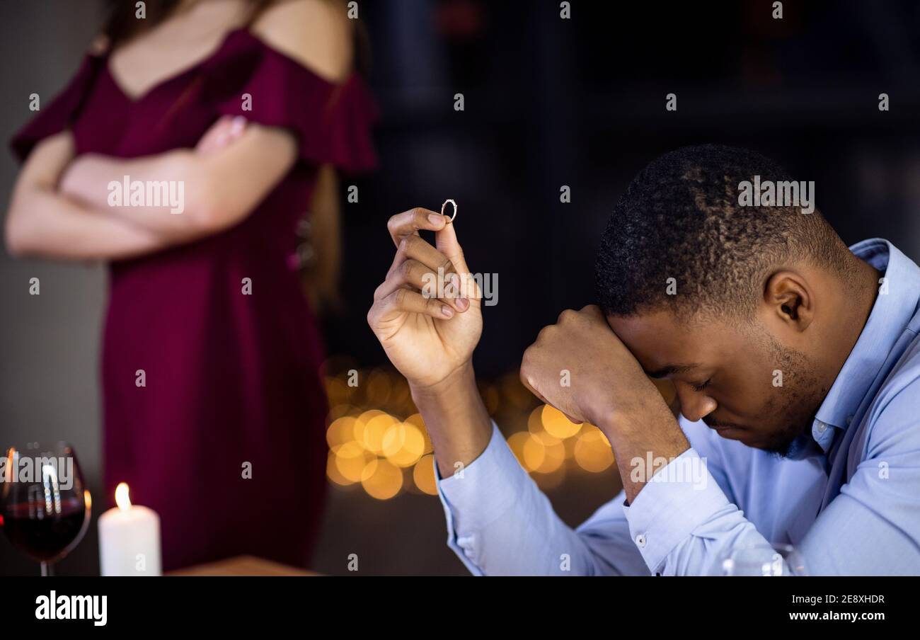 Desperate Black Man Sitting With Ring In Hand After Girlfriend Refused Proposal Stock Photo
