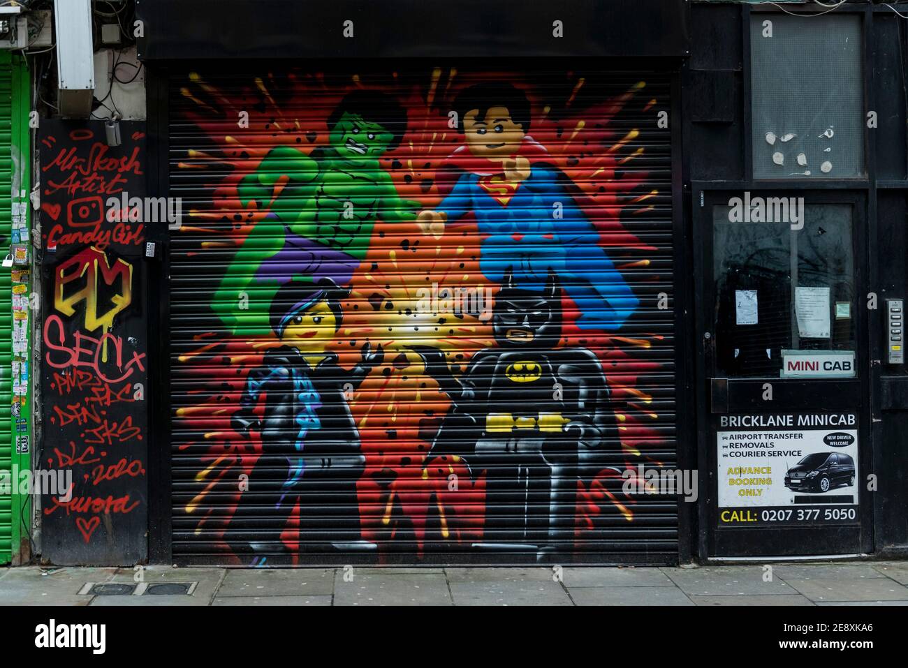 London, UK. 1 February 2021. Lego-style superhero-inspired street art on  the shutters of a closed business in a very quiet Brick Lane in East London  as concern over the severity of a