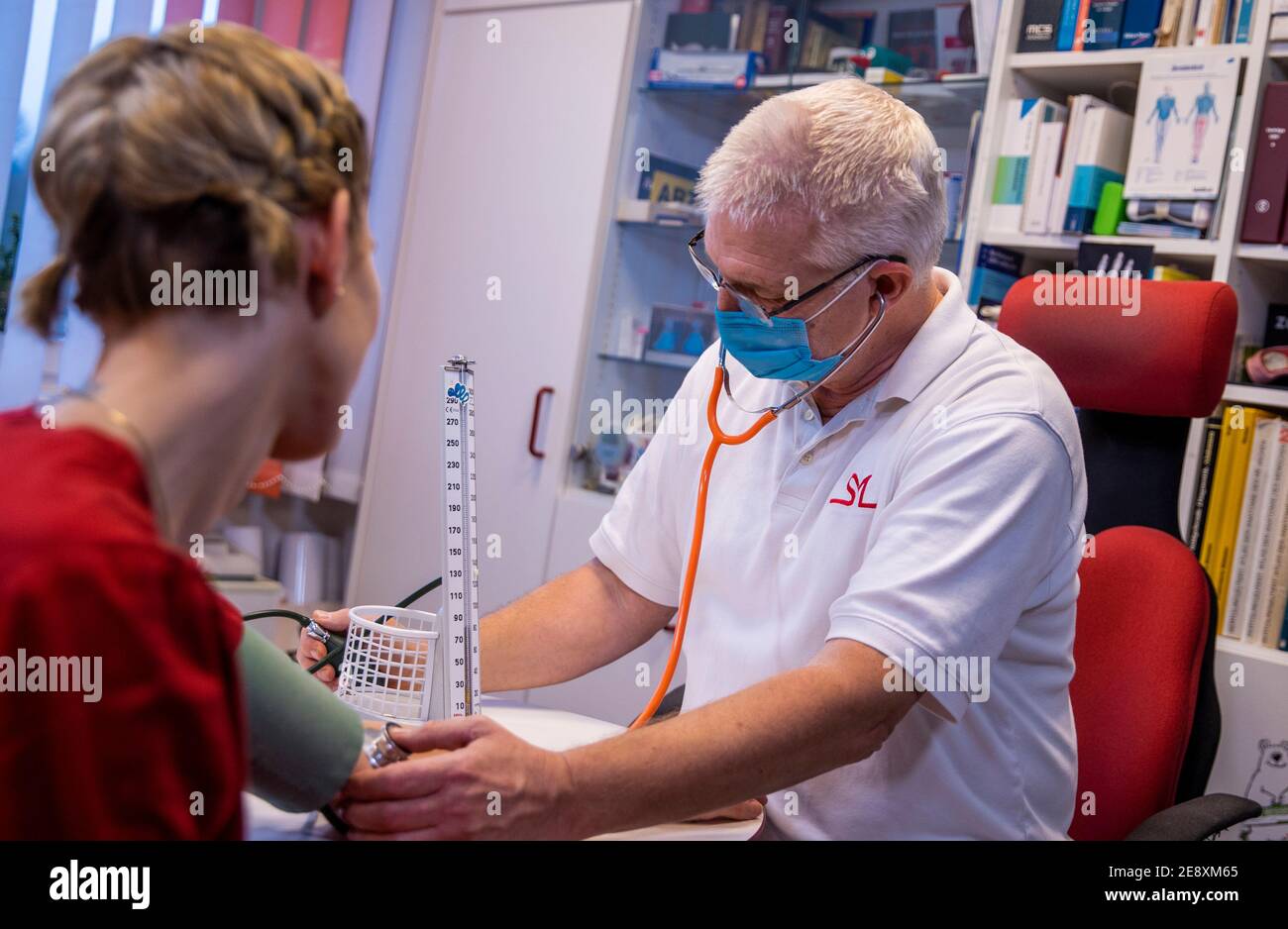 Schwerin, Germany. 08th Dec, 2020. Siegfried Mildner measures the blood pressure of a patient in one of the treatment rooms of a family doctor's practice. Credit: Jens Büttner/dpa-Zentralbild/ZB/dpa/Alamy Live News Stock Photo