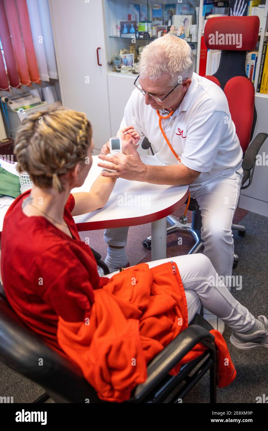 Schwerin, Germany. 08th Dec, 2020. Siegfried Mildner measures the blood pressure of a patient in one of the treatment rooms of a family doctor's practice. Credit: Jens Büttner/dpa-Zentralbild/ZB/dpa/Alamy Live News Stock Photo