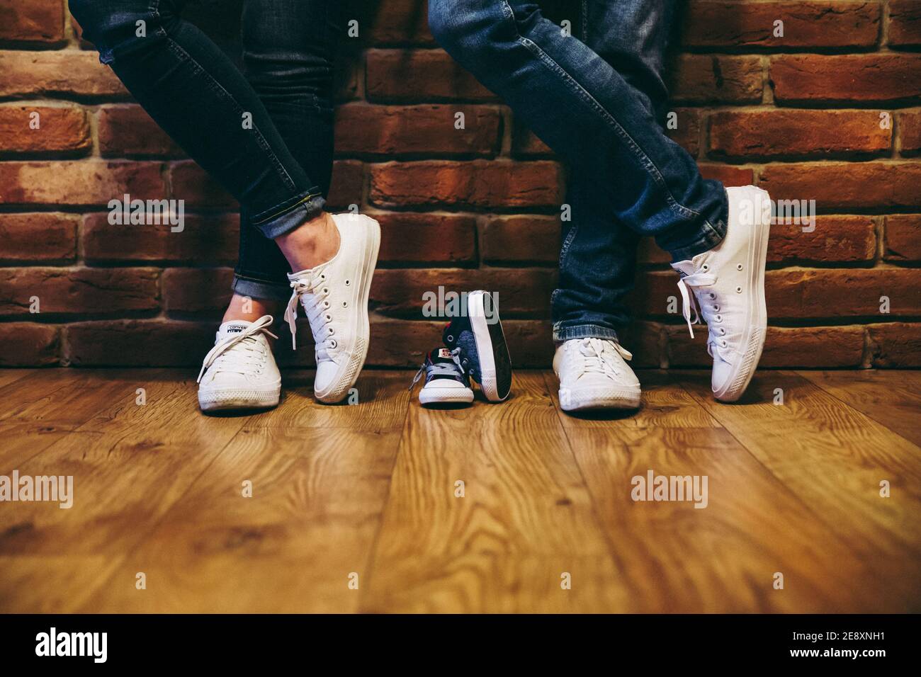 Waiting of baby. Converse shoes of parents and baby in the middle. Mom and  dad to be Stock Photo - Alamy