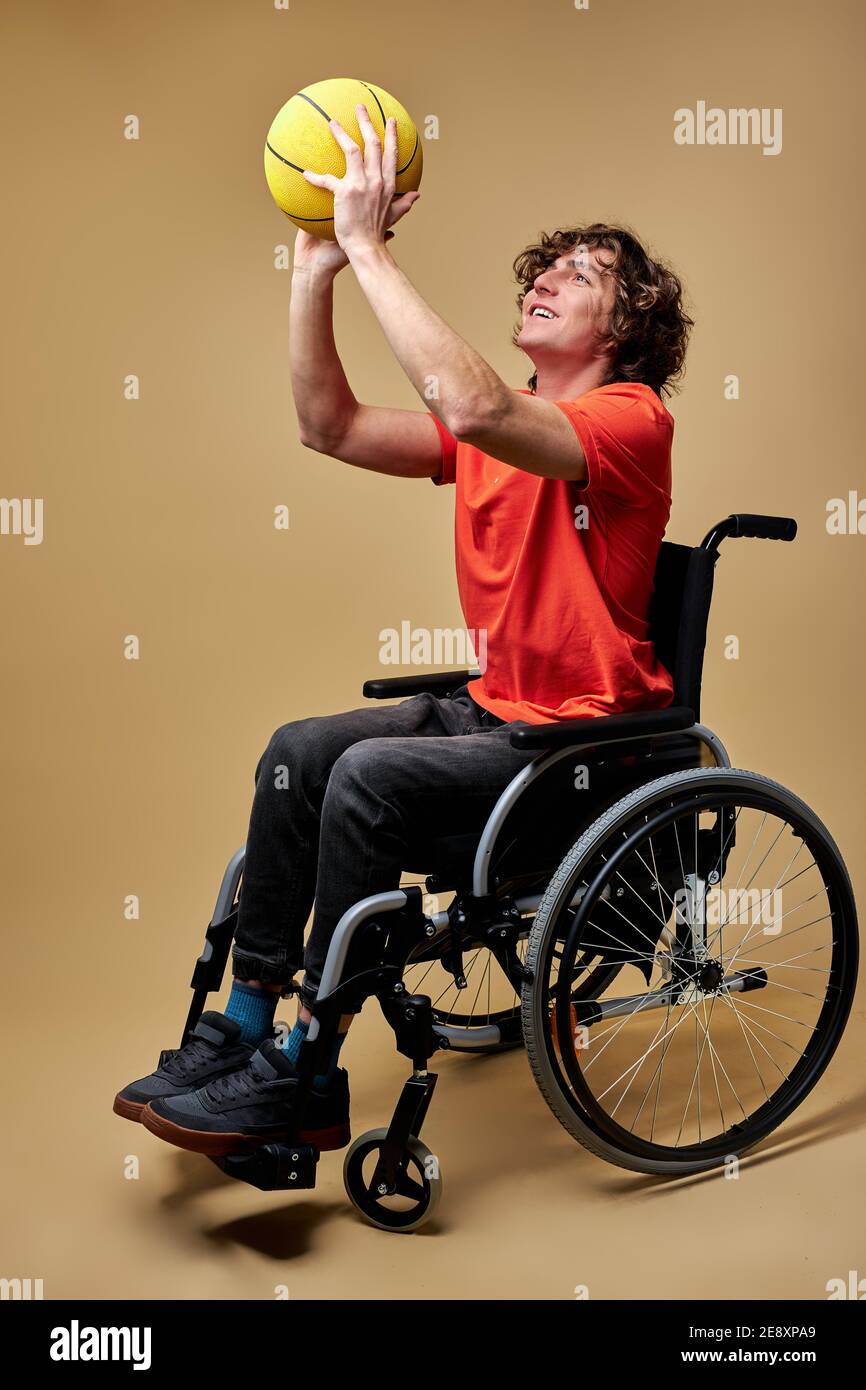 disabled man in wheelchair train with basketball ball, caucasian