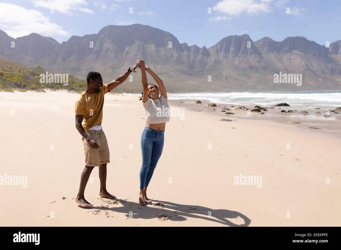 African american couple having fun dancing on a beach by the sea Stock Photo