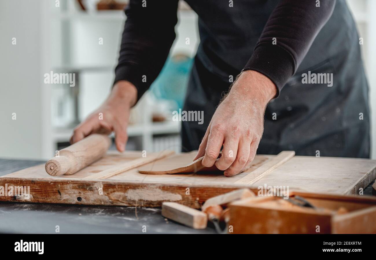 Man using rolling pin on clay Stock Photo Alamy