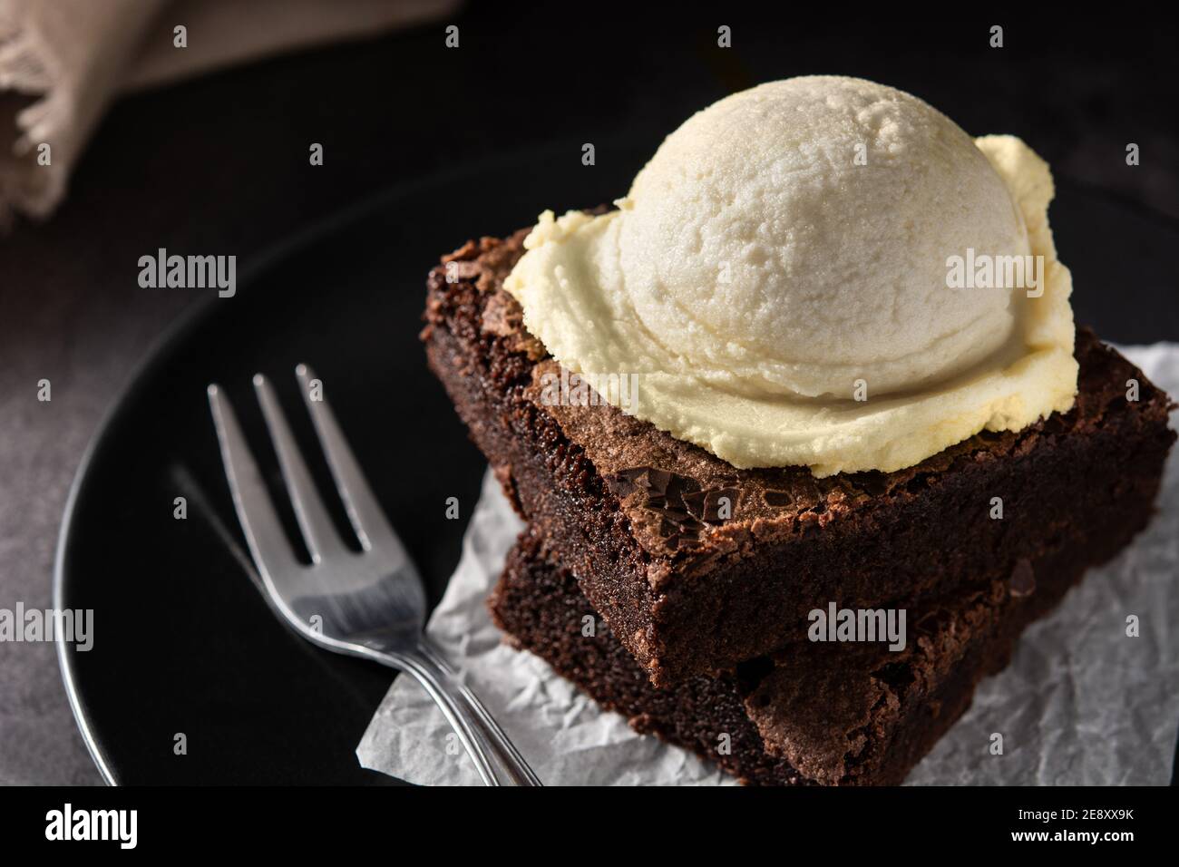 Brownie with vanilla ice cream scoop on black background Stock Photo ...