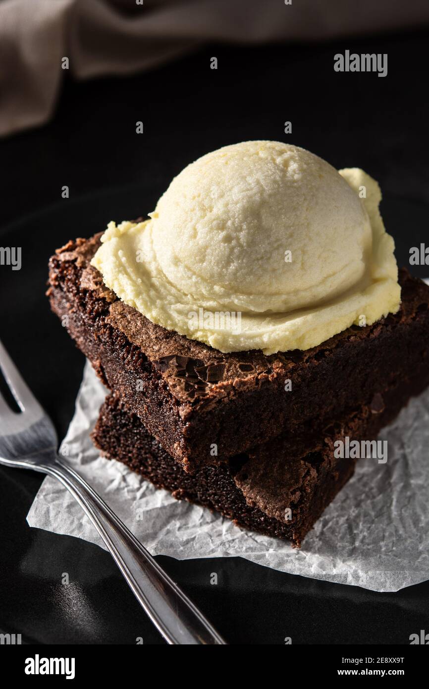 Brownie with vanilla ice cream scoop on black background Stock Photo ...