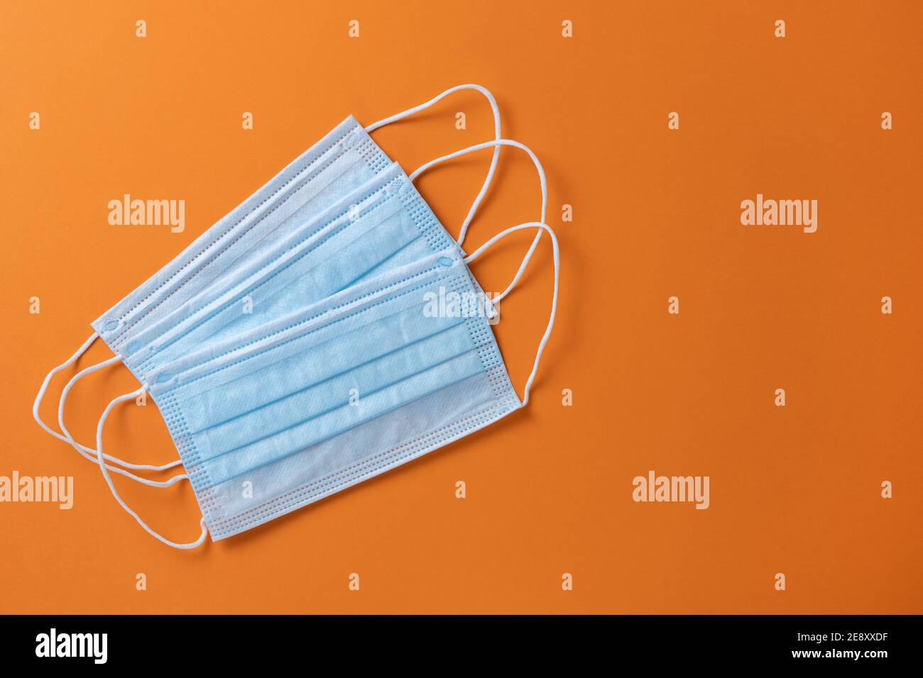 Medical protective, blue face masks, on orange background, closeup