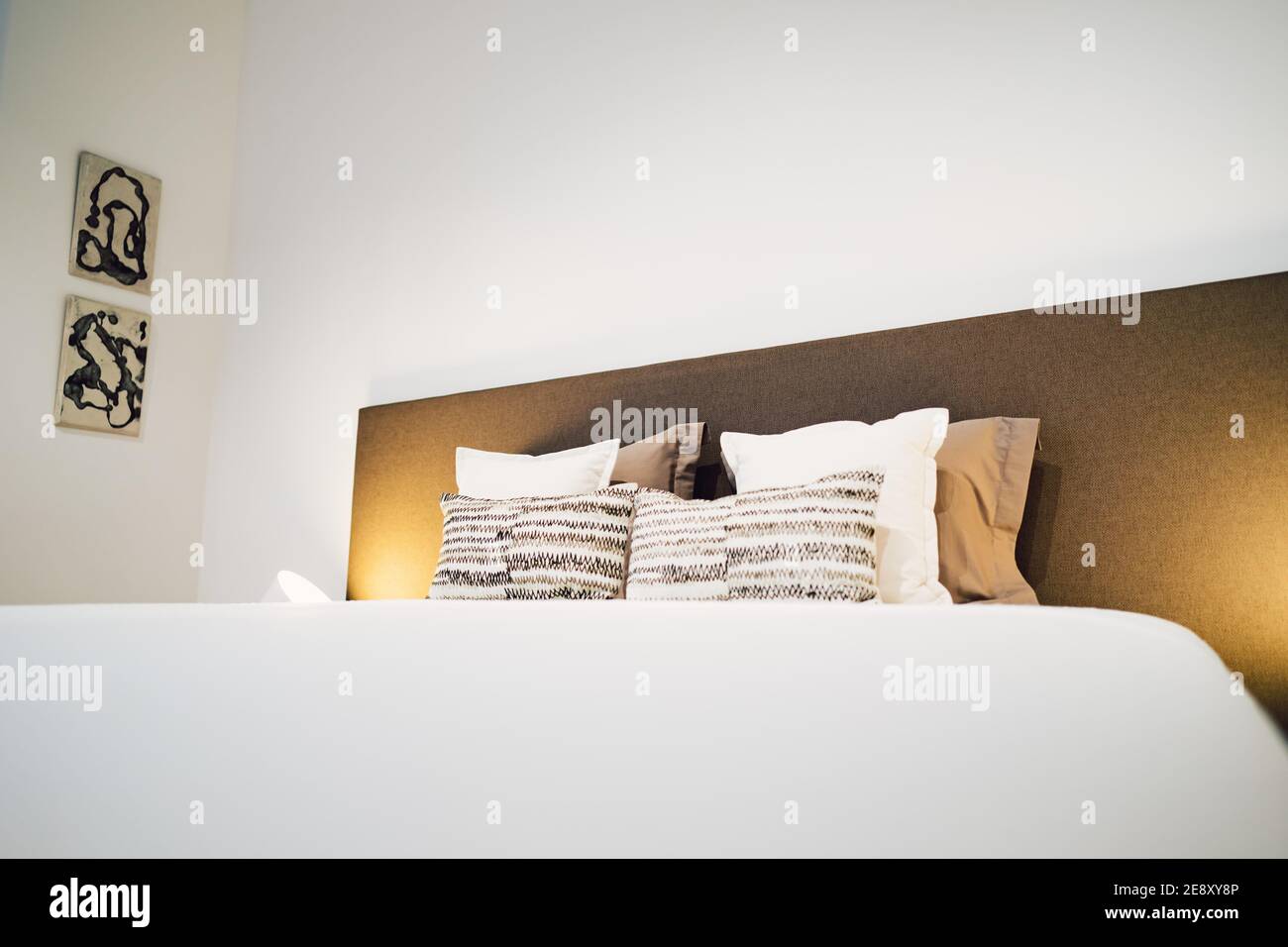 a bed in a simple modern bedroom Stock Photo - Alamy