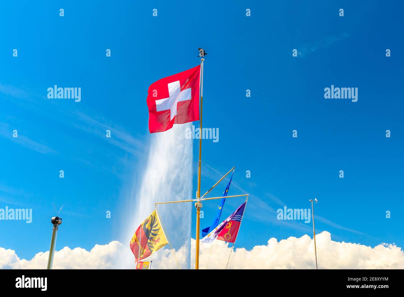 Swiss Flag, European flag and Canton of Geneva Flag and on background the most famous attraction and symbol of the city, Jet d'eau fountain in Leman Stock Photo
