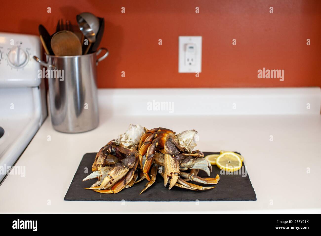 Raw, cleaned, uncooked Dungeness crab legs sit on a platter in the