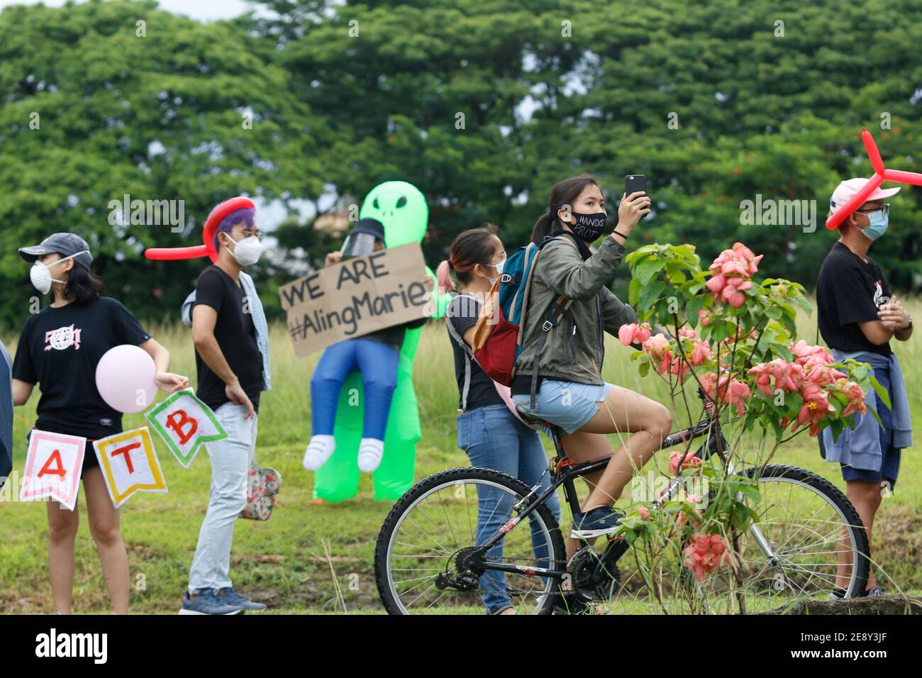 A female photographer on a bike trying to take photos of the ongoing protest against the passing of Anti Terrorism Law. June 12, 2020, Quezon City Philippines. Stock Photo
