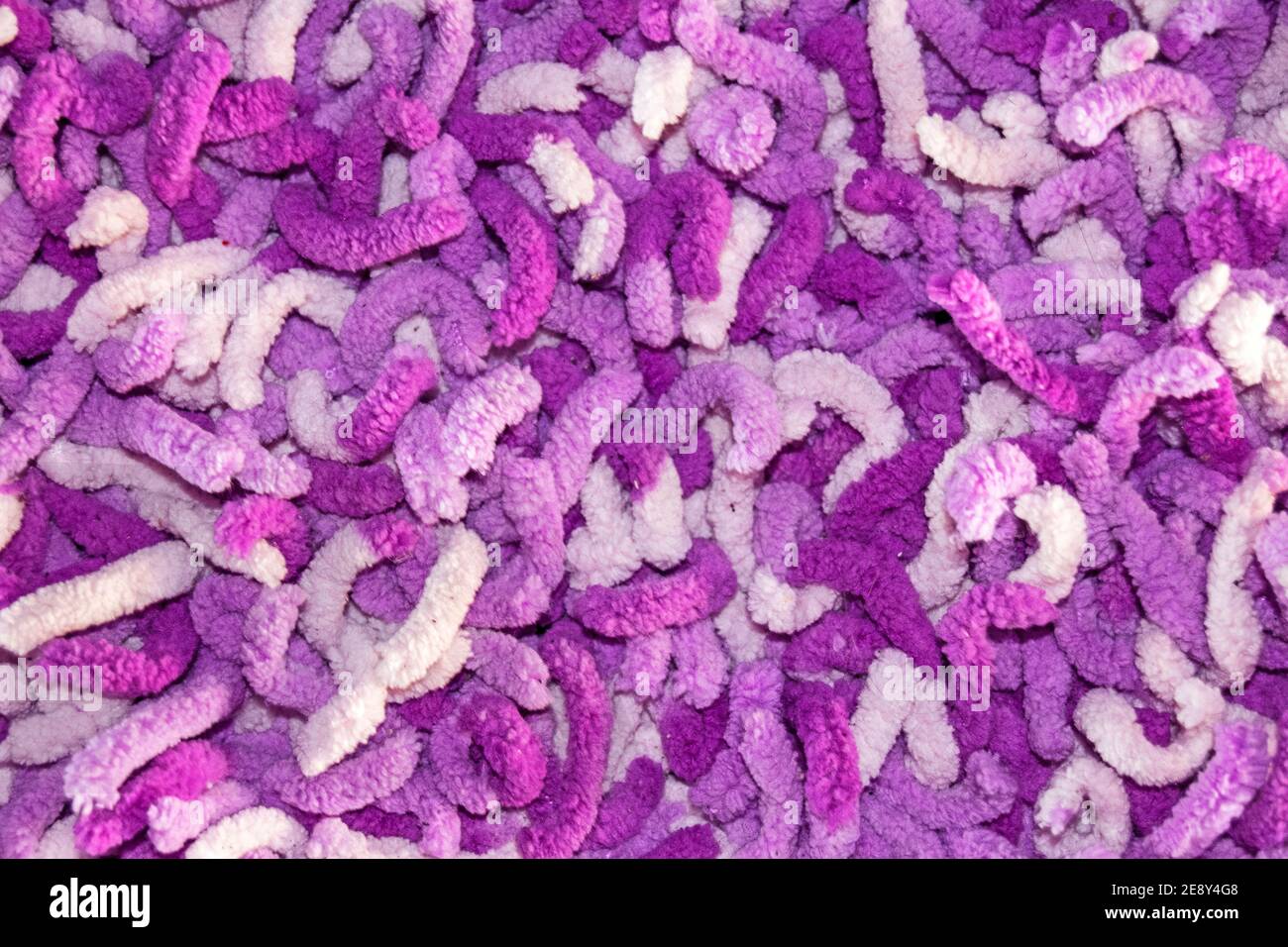Texture of long hair carpet in purple and pink, fur texture closeup for designers and backgrounds Stock Photo