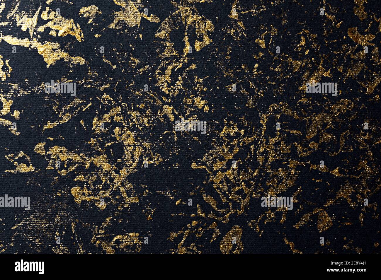 Abstract gold paint on black textured paper Stock Photo