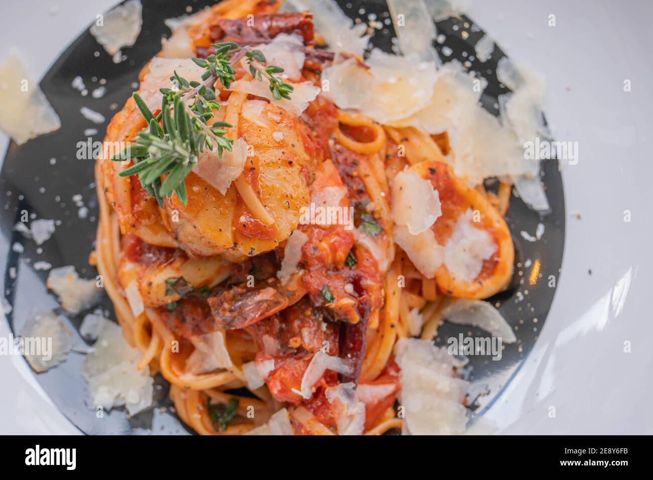Spaghetti with prawns, sea scallops and parmesan Stock Photo