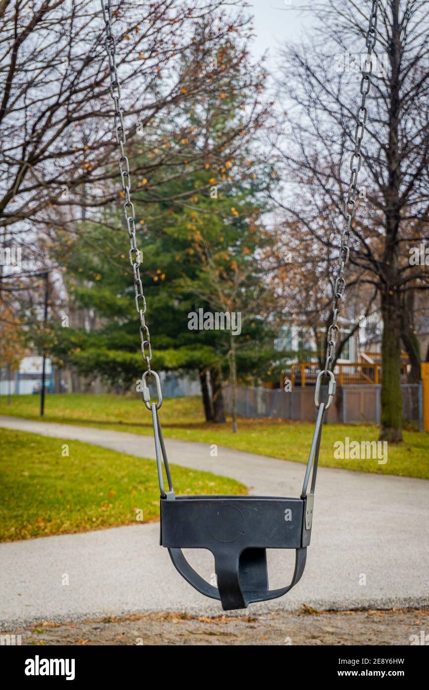 Empty chain swing in children playground illustrating covid lockdown situation Stock Photo