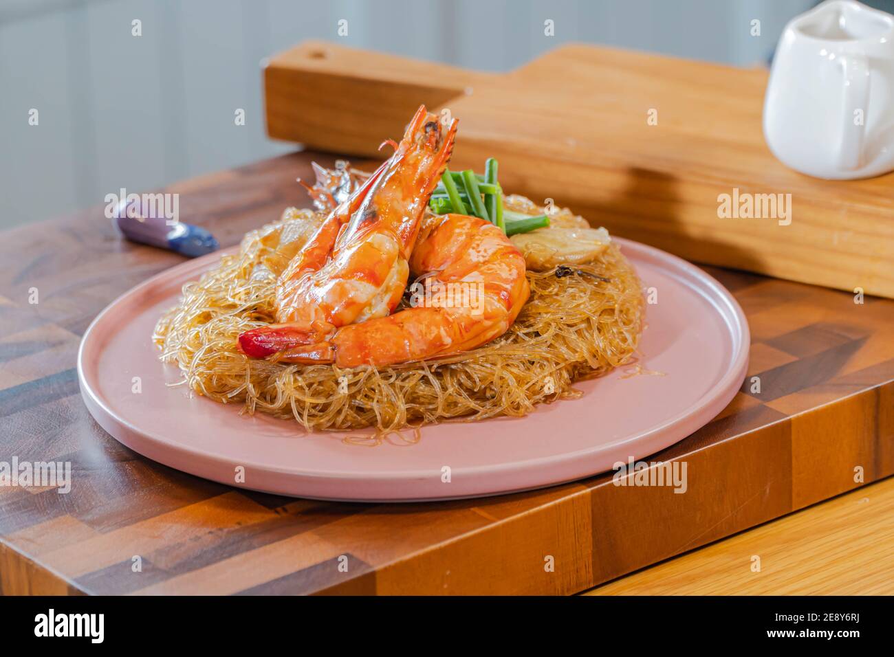 Baked Shrimp with Glass Noodles, a traditional Thai food wrapped in heat-treated freud paper and chopsticks, ready to serve-eat Stock Photo