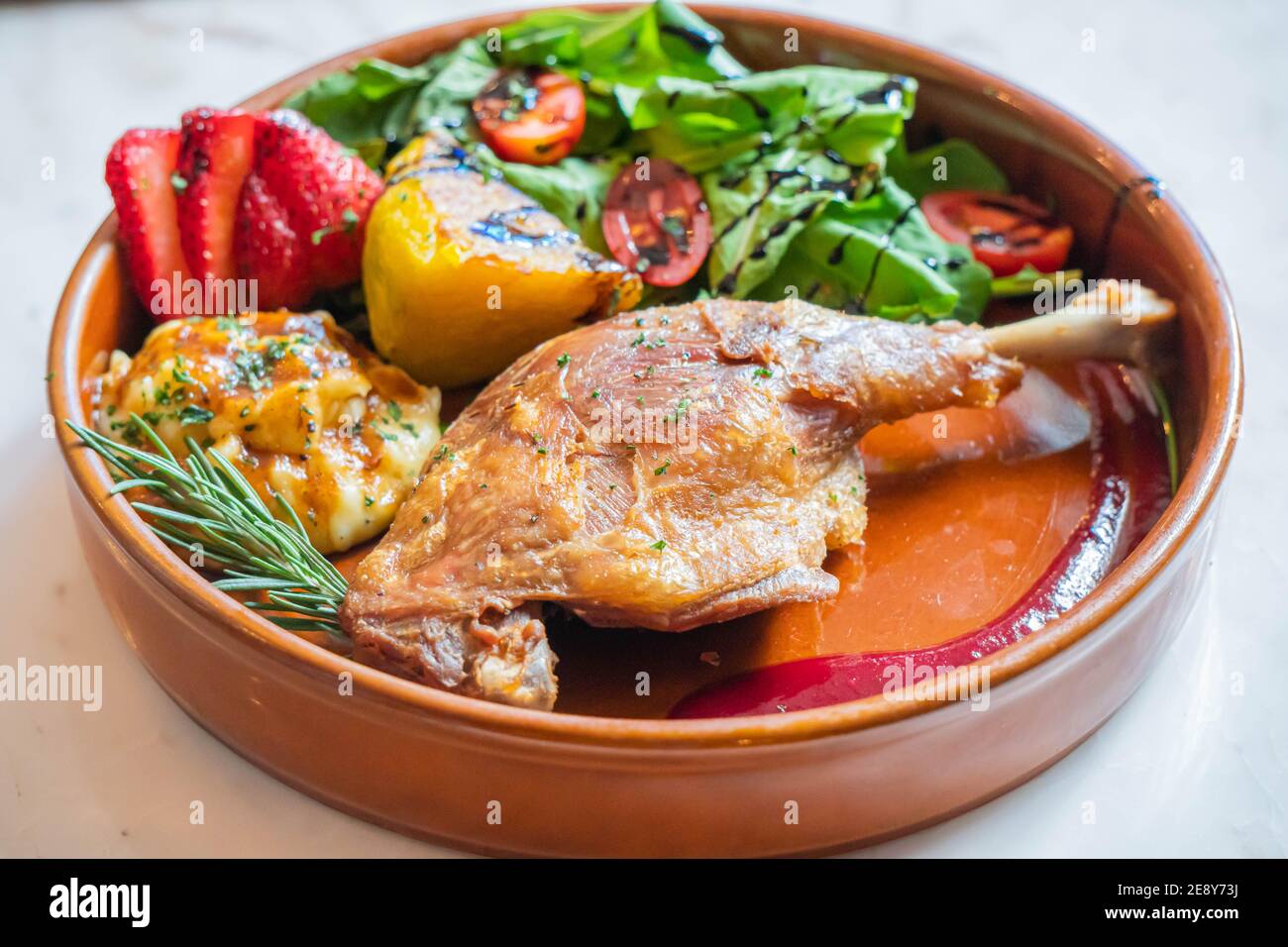 Hot fried chicken legs with grilled pineapple and Strawberry,Tomato with vegetable Stock Photo