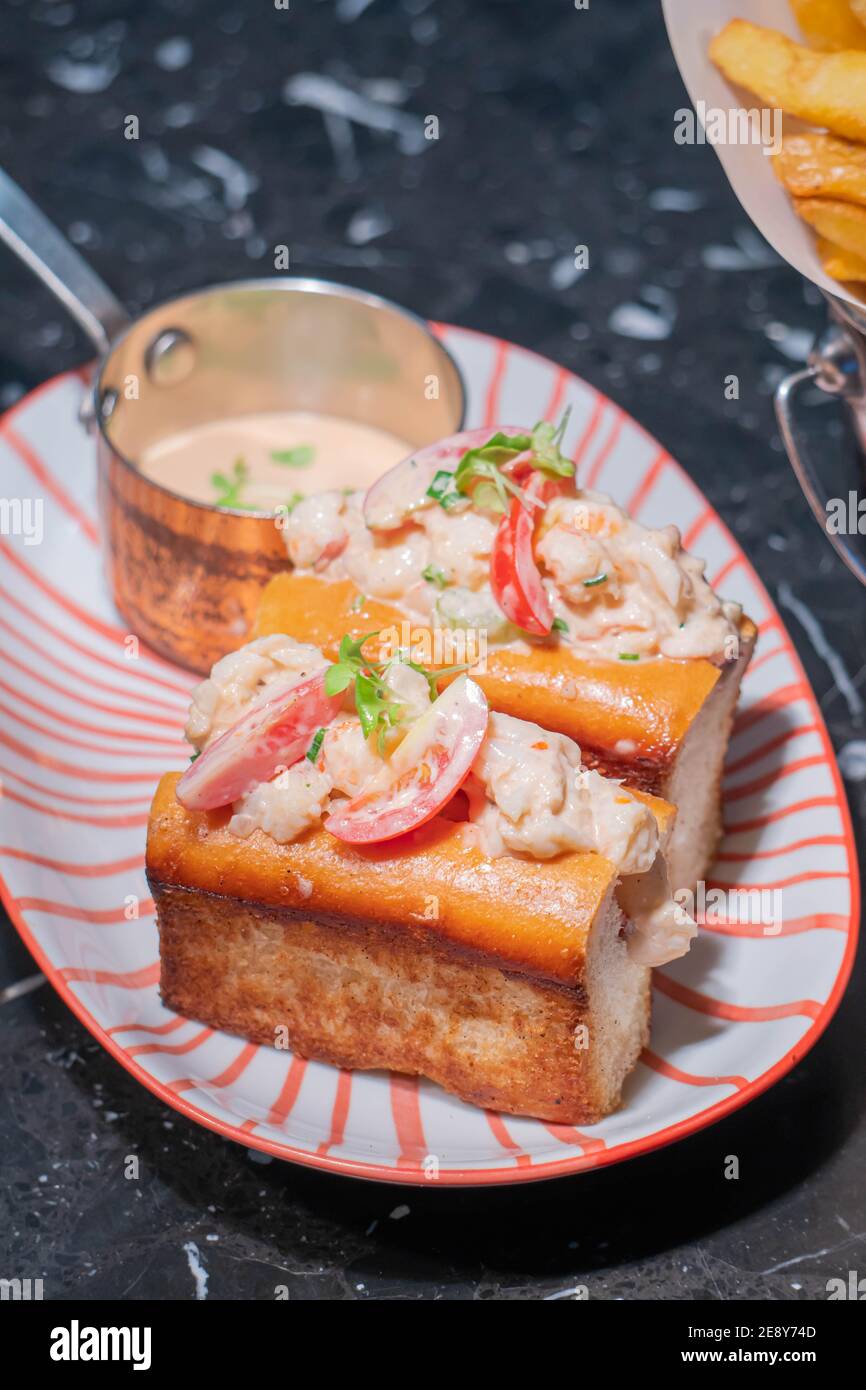 Lobster Roll.fresh Maine Lobster boiled, mixed with mayo, celery, chives served in toasted hero roll with crisp lettuce and drawn butter. Stock Photo