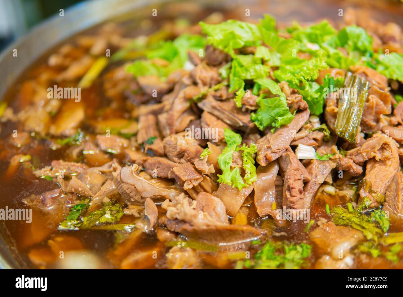 Macro close up shot of Pork stewed in the gravy with green coriander leaves on top and soup. Thai food. Stock Photo