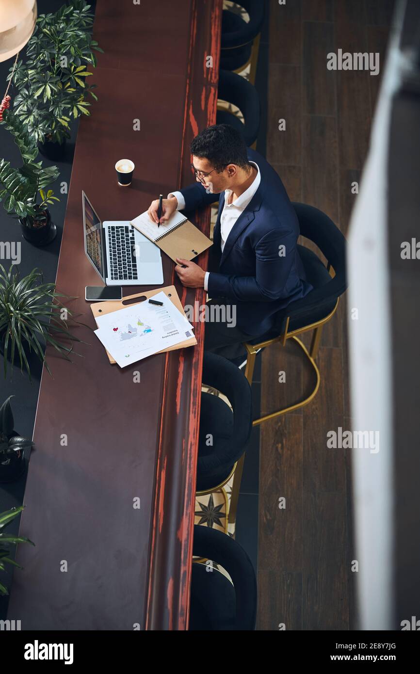 Concentrated stylish male in eyeglasses taking notes Stock Photo