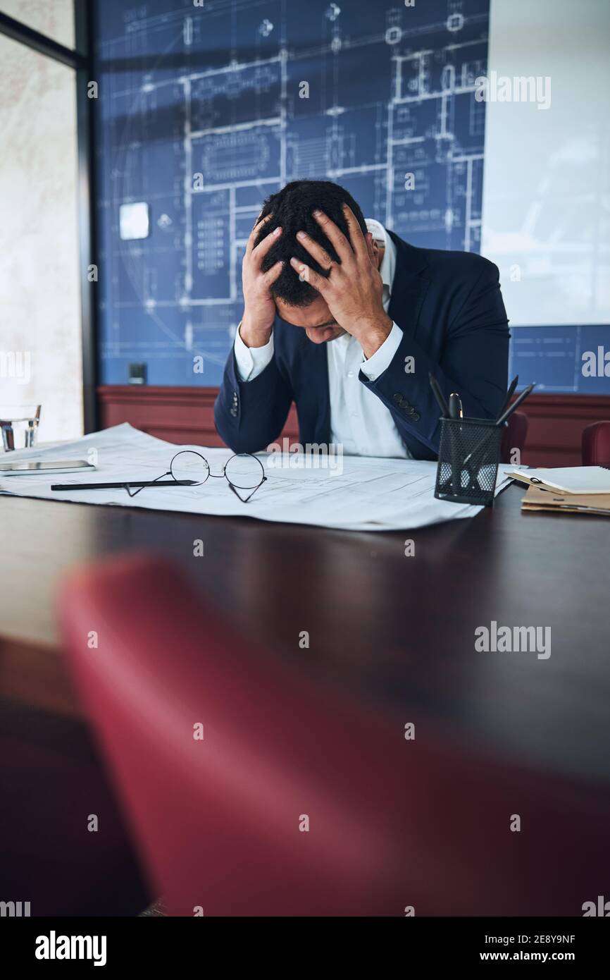 Draftsman having a severe headache in the workplace Stock Photo